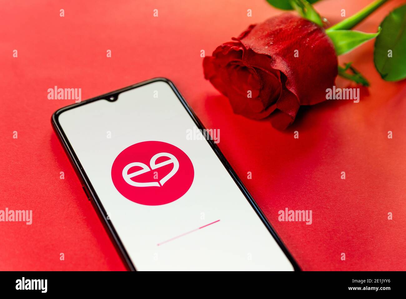 Londra, UK - 6 gennaio 2021: Primo piano della chiusura del logo dell'app meetic dating sul telefono cellulare con rosa rossa. Concetto di datazione online . Romantico appartamento su cui poggiare Foto Stock