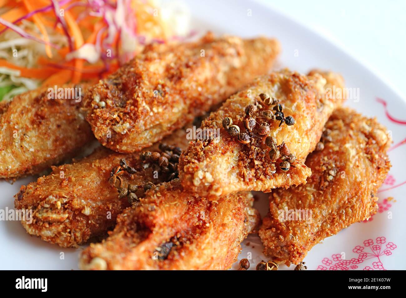 Primo piano di ali di pollo fritte profonde in stile tailandese settentrionale con piatti caldi Ed erbe speziate Foto Stock