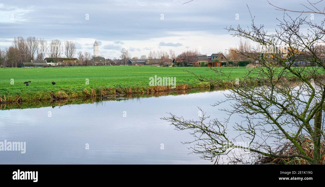 Vista del paesaggio olandese polder con la torre di Il villaggio di Meije visibile Foto Stock