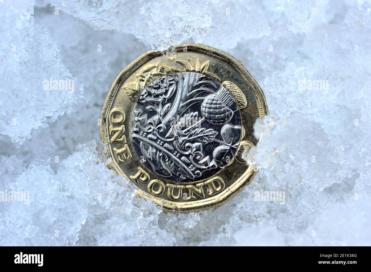 BRITISH UNA LIBBRA MONETA IN NEVE E GHIACCIO RE ECONOMIA SALARI REDDITI PENSIONI INVERNO ECC REGNO UNITO Foto Stock
