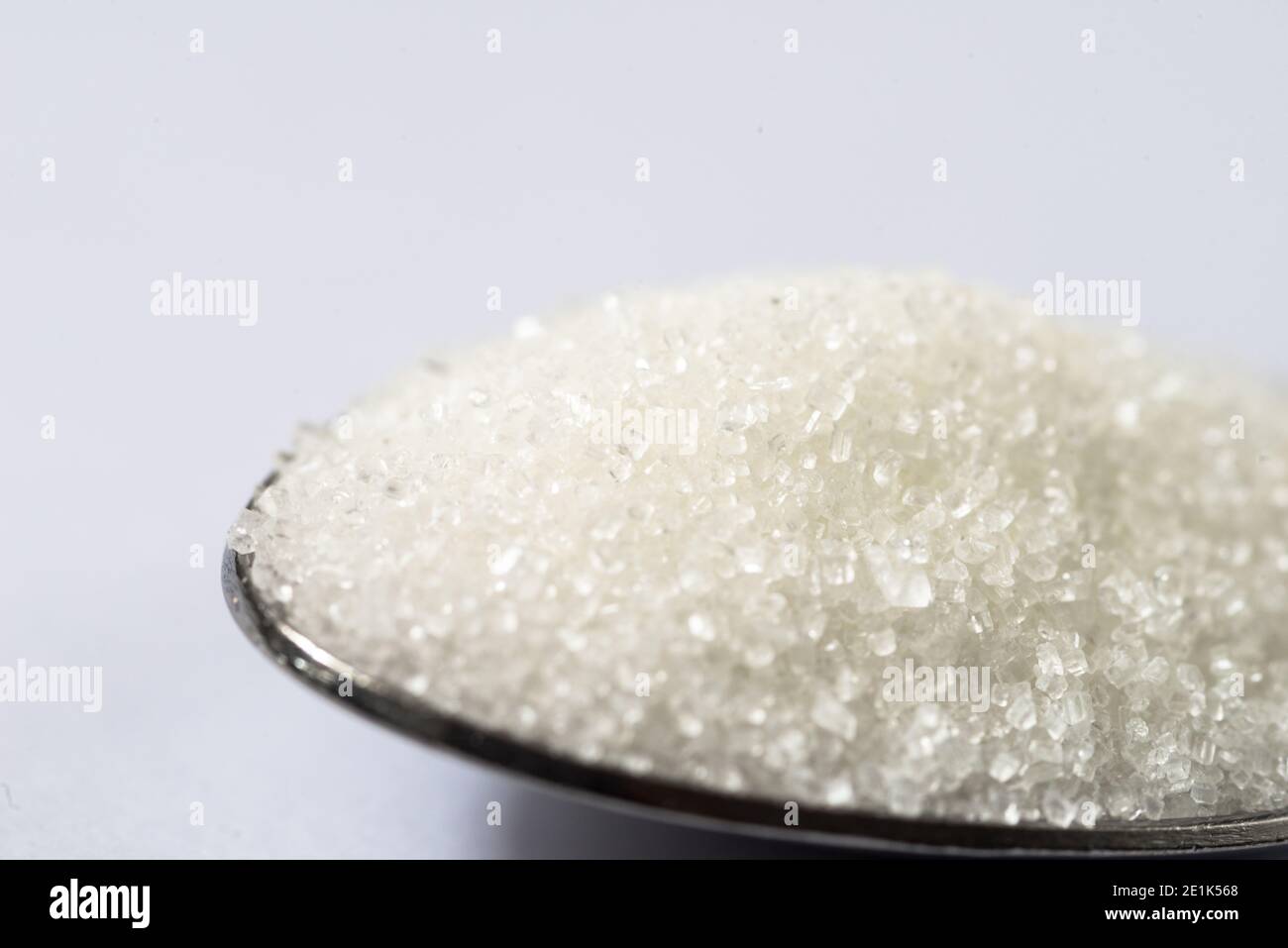 Tavola cucchiaio di zucchero su sfondo bianco Foto Stock