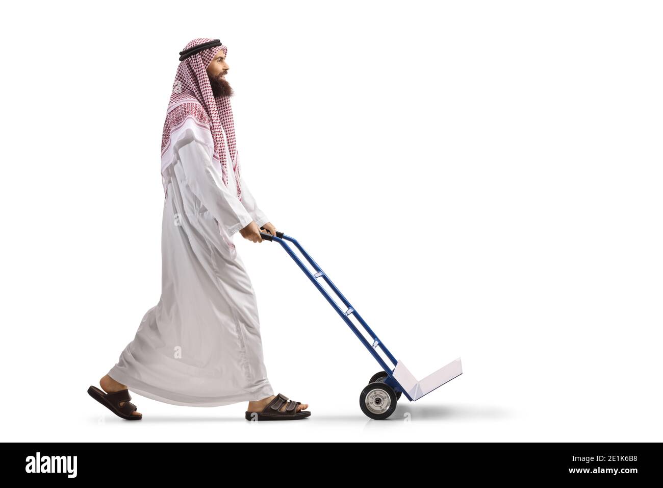 Foto di un uomo arabo saudita che spinge a tutta lunghezza un carrello a mano vuoto isolato su sfondo bianco Foto Stock