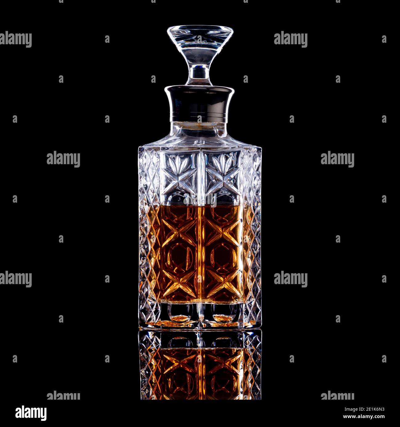 Decanter in vetro a lati dritti contenente whisky, brandy o rum su sfondo nero Foto Stock