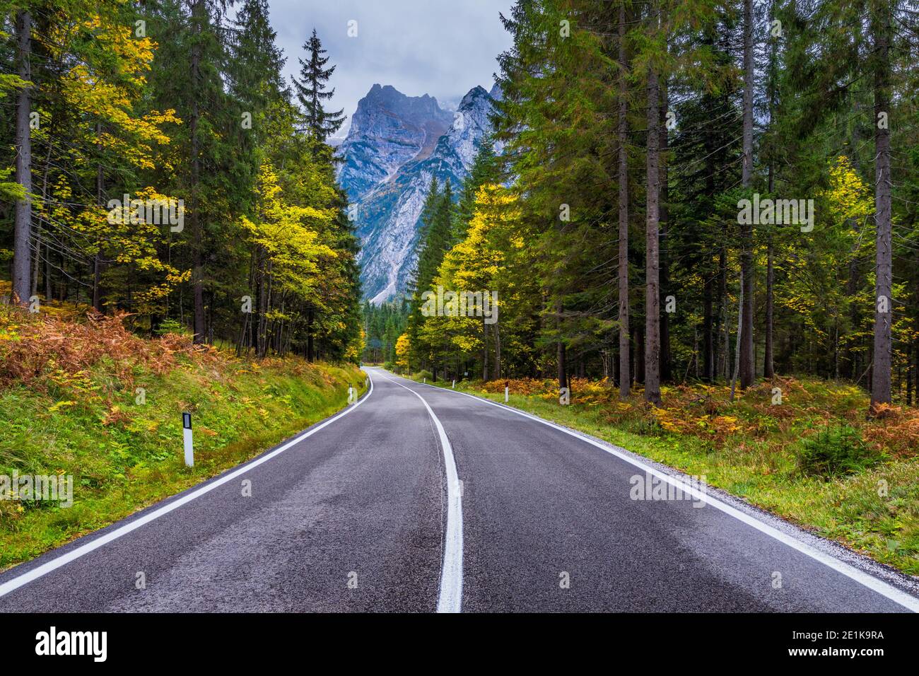 Strada di Montagna. Paesaggio con rocce, cielo sereno con le nuvole e la bella strada asfaltata in serata d'estate. Tonificazione vintage. Sfondo di viaggio. Hig Foto Stock