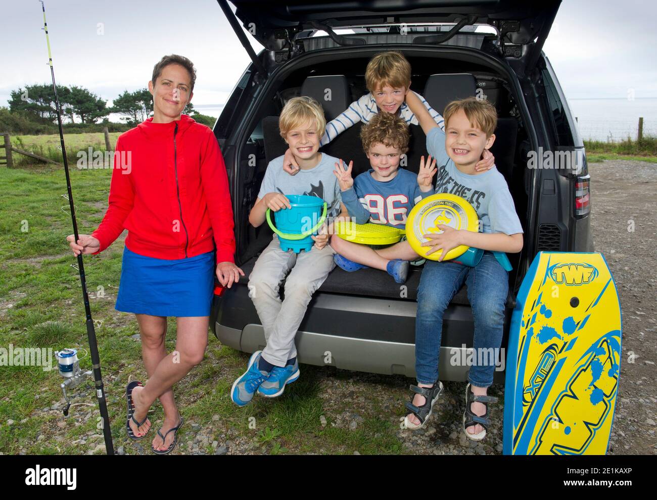 Una giovane madre con i suoi 4 figli e Land Rover Discovery, in vacanza in Cornovaglia. Foto Stock