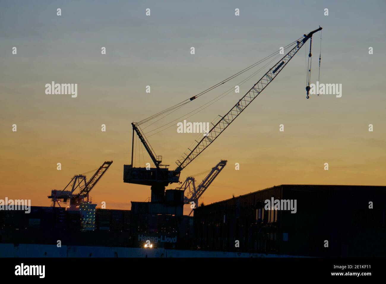 Seaport, autogru per il commercio internazionale al tramonto. Silhouette di macchinari. Outer Harbour, Porto di Oakland, California, Stati Uniti Foto Stock