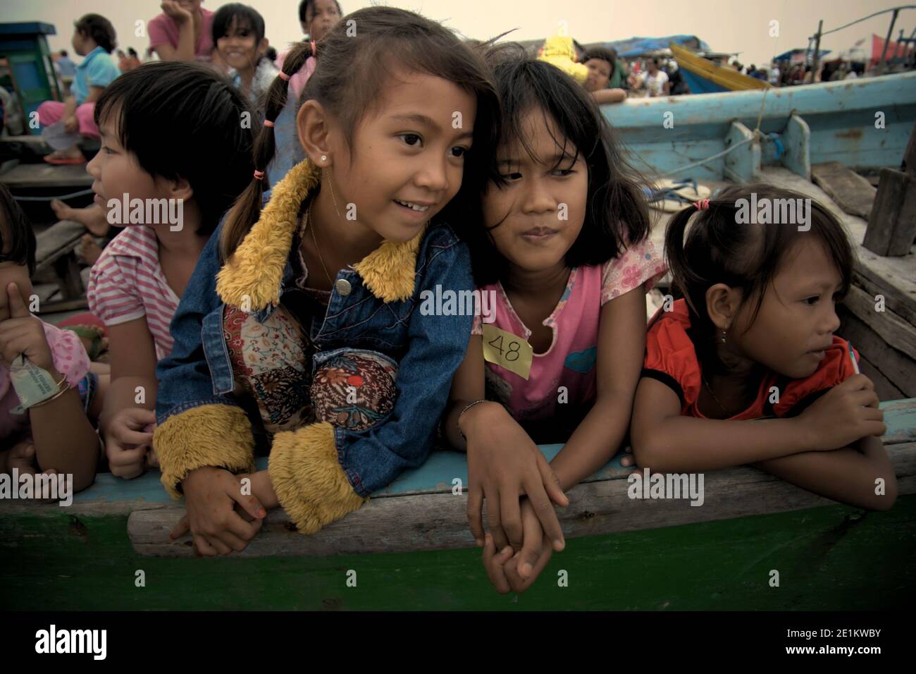 Bambini che giocano su imbarcazioni da pesca nella zona costiera intermariana durante un evento di sensibilizzazione ambientale del pubblico tenuto da Walhi (il Forum indonesiano per l'ambiente) nel villaggio di pescatori di Marunda, Jakarta settentrionale, Giacarta, Indonesia. Foto Stock