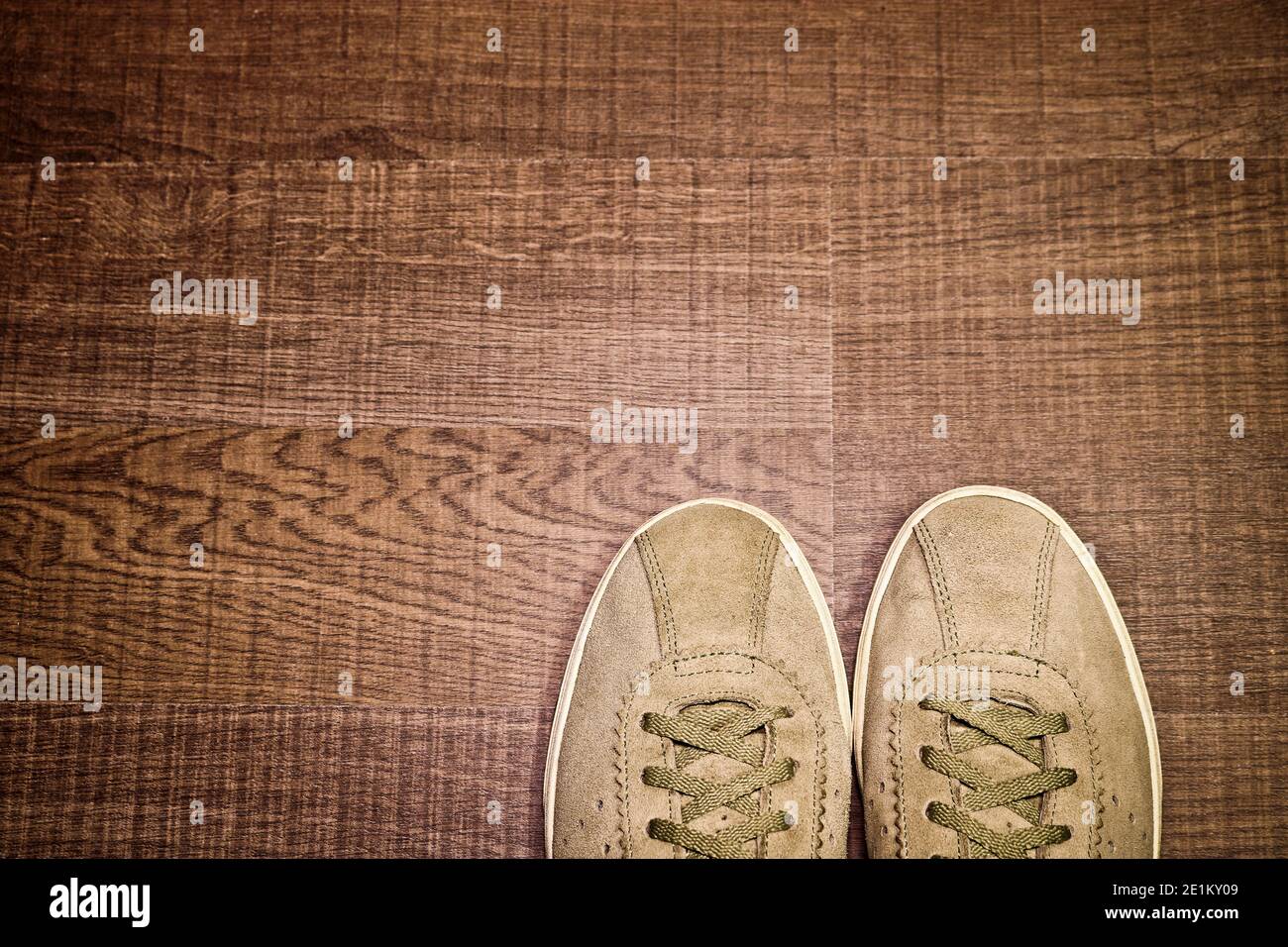 Sneaker vintage in pelle scamosciata naturale su pavimento in legno, vista dall'alto, con spazio per il testo. Concetto di viaggio. Foto Stock
