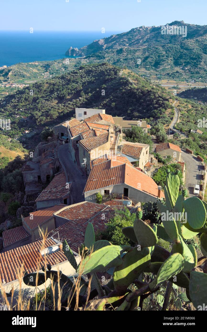 Vista sulla costa orientale della Sicilia dalla città di Savoca sulle colline siciliane, tetti in tegole, paesaggio collinare coperto di vegetazione e mare blu Foto Stock