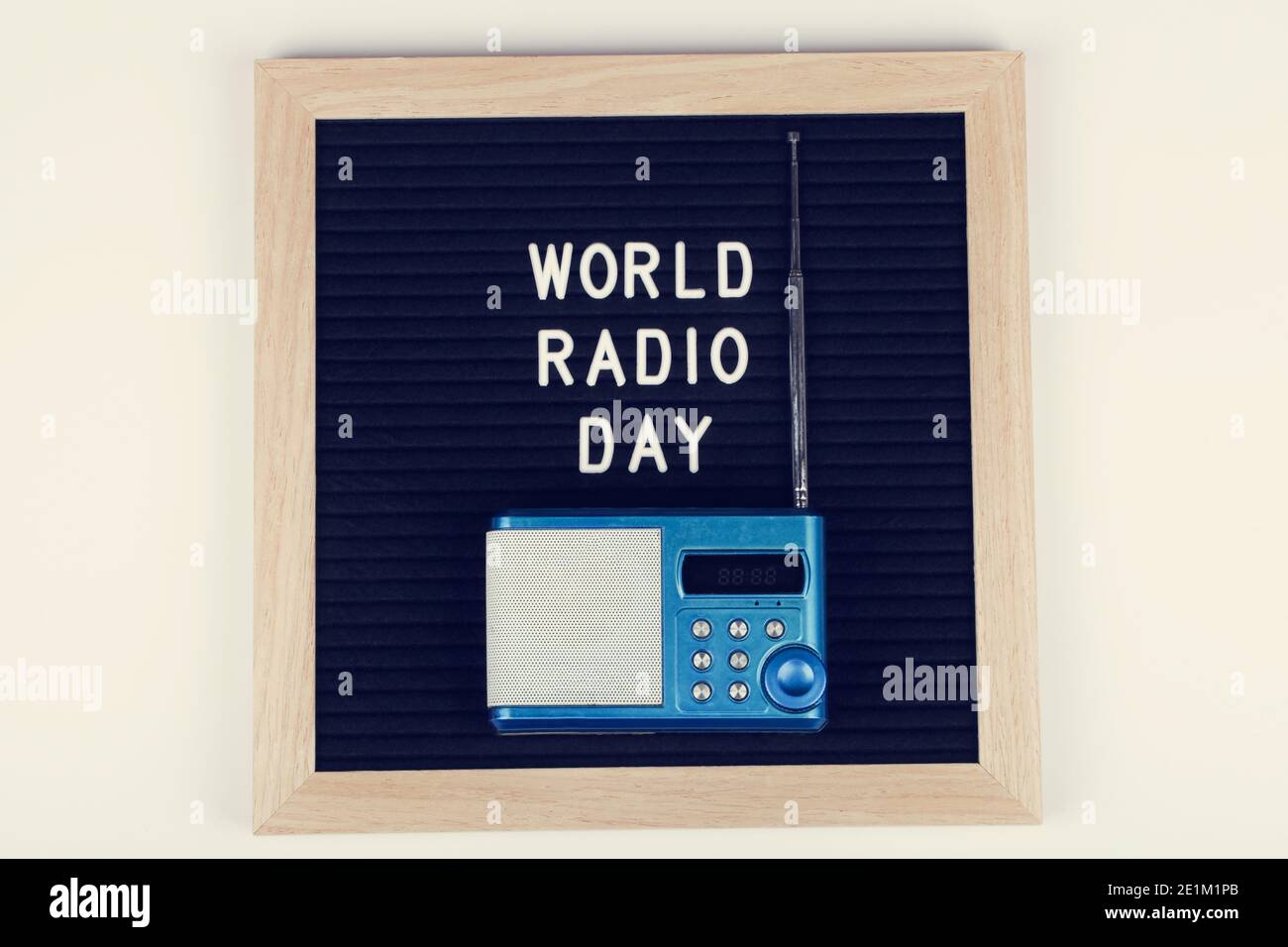 lavagna nera con testo mondo radio giorno con radio blu su sfondo bianco. Vista dall'alto. Disposizione piatta sfondo minimo. Foto Stock
