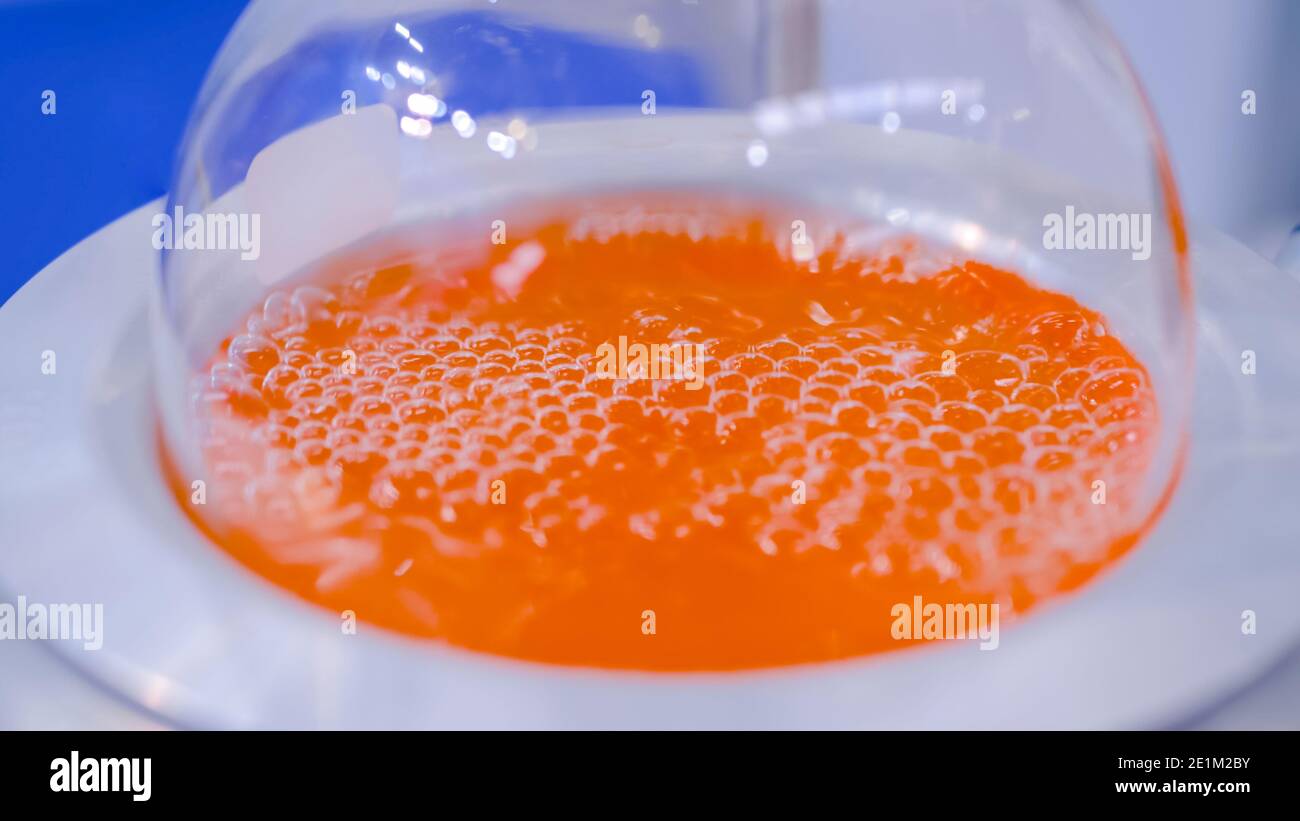Apparecchi di riscaldamento per matracci da laboratorio a fondo tondo - liquido arancione bollente: Closeup Foto Stock
