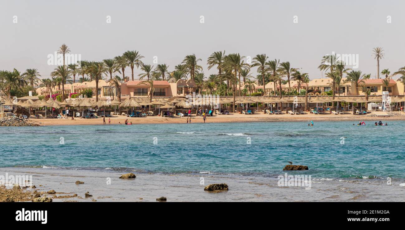 Hurghada, Egitto - Settembre 29 2020: Spiaggia con palme a Hurghada, turisti con lettini e ombrelloni nella calda giornata estiva. Foto Stock