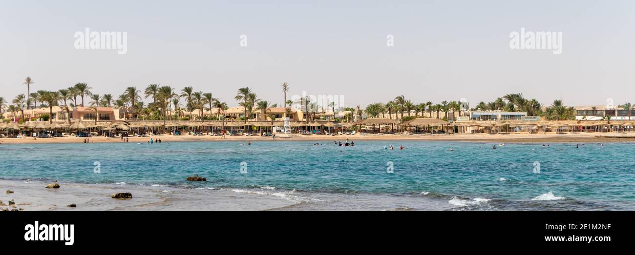 Hurghada, Egitto - Settembre 29 2020: Spiaggia con palme a Hurghada, turisti con lettini e ombrelloni nella calda giornata estiva. Foto Stock