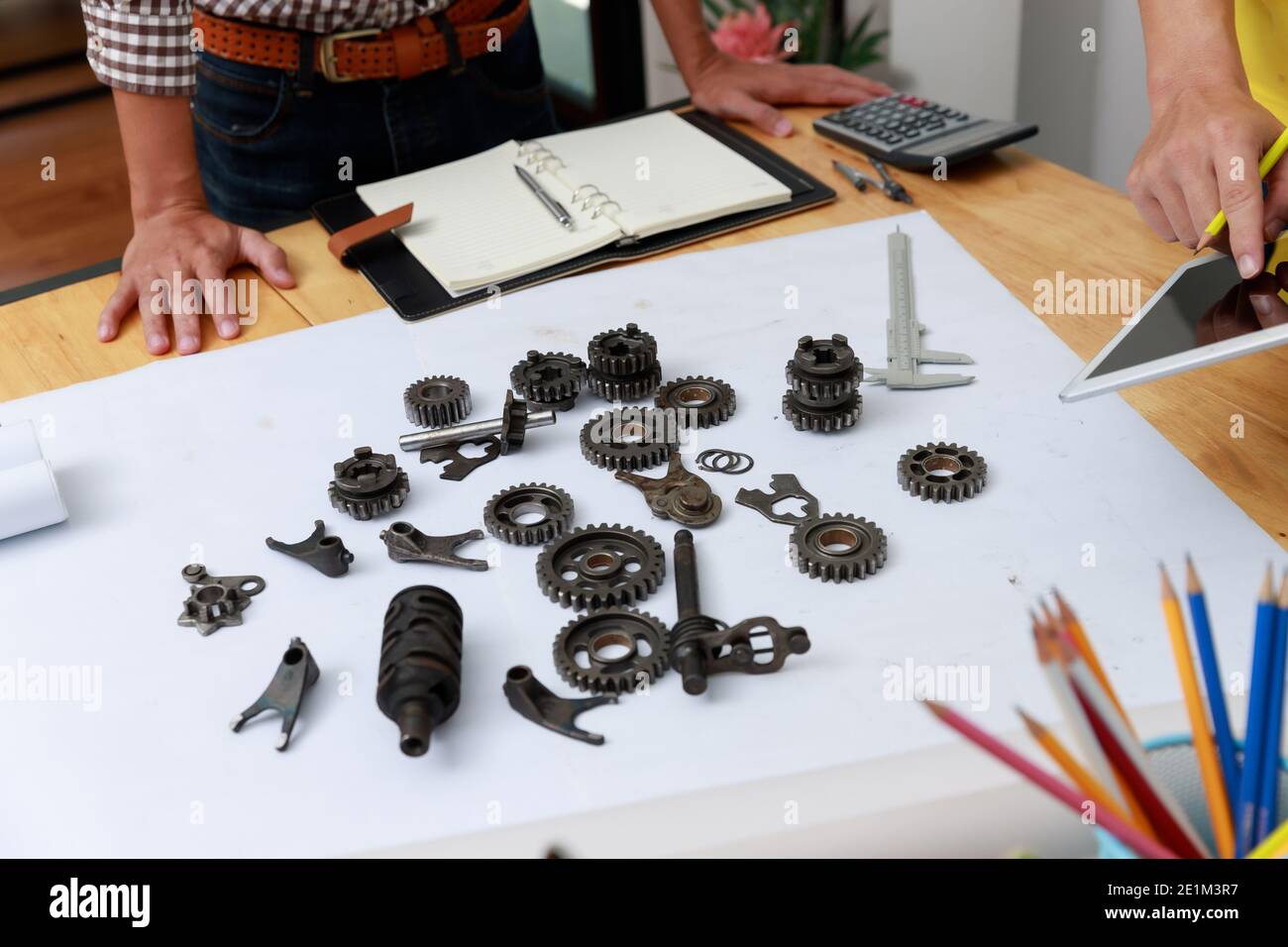 Ingegnere discutendo e progettazione circa la marcia meccanica parti in ufficio. Foto Stock