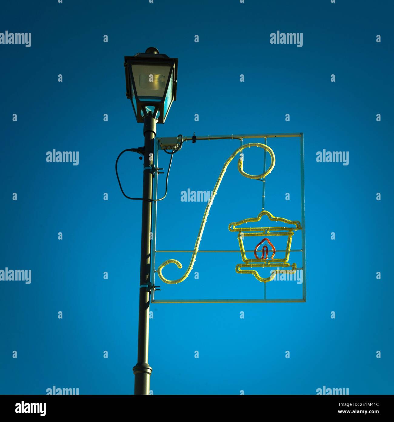 Lampione decorativo luminoso con ornamenti festosi su un cielo azzurro. Decorazione natalizia di strada. Francia Foto Stock