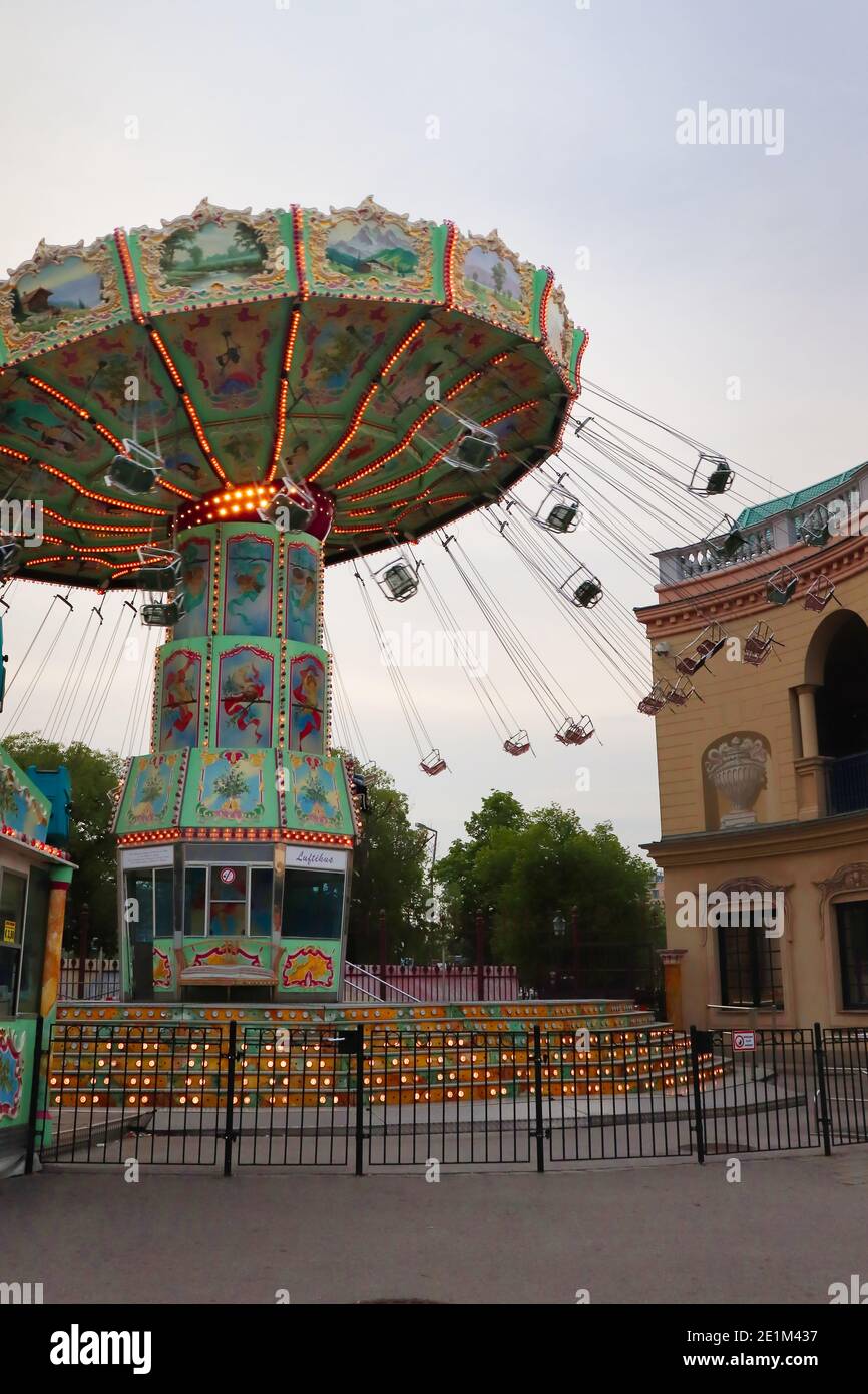 Giro in altalena al parco divertimenti Prater di Vienna, in Austria, in una serata primaverile. Foto Stock