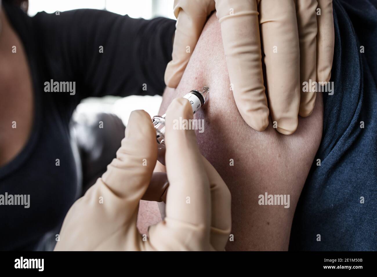 l'infermiere inietta il vaccino nella spalla Foto Stock