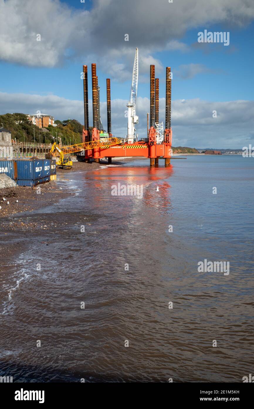 Wave Walker Jack-up chiatta aiutare la costruzione di un nuovo grande muro di mare a Dawlish proteggere la ferrovia, Devon, Inghilterra. Foto Stock