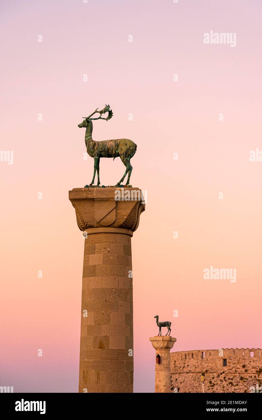 Il tramonto del bronzo statue di cervo all'ingresso Mandraki Harbour, Rodi, Rodi, Grecia Foto Stock