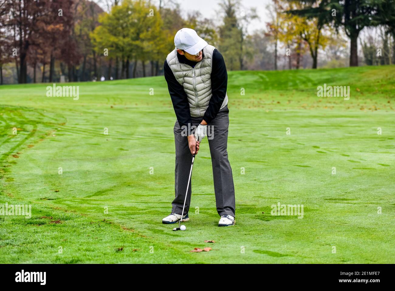 Giocatore di golf sul campo mettendo, lui mira al suo colpo messo Foto Stock