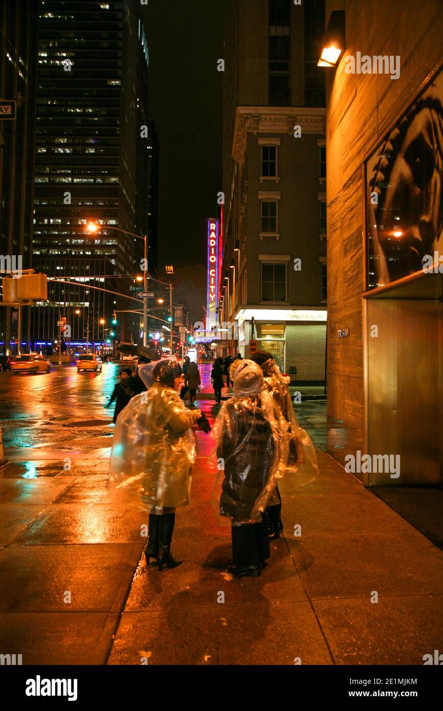 Gruppo di turisti che indossano coperte di plastica per le strade di New York durante una serata d'inverno, Manhattan, America Foto Stock