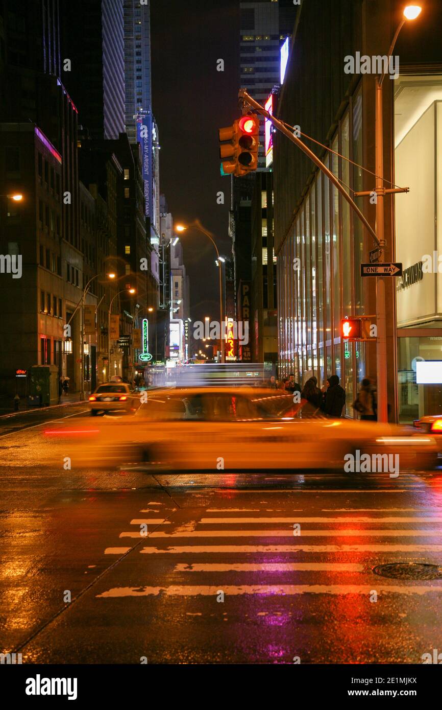 New York durante la sera con luci di strada e taxi giallo che velocizza da, 5th Avenue, New York, Manhattan, USA, America. Foto Stock