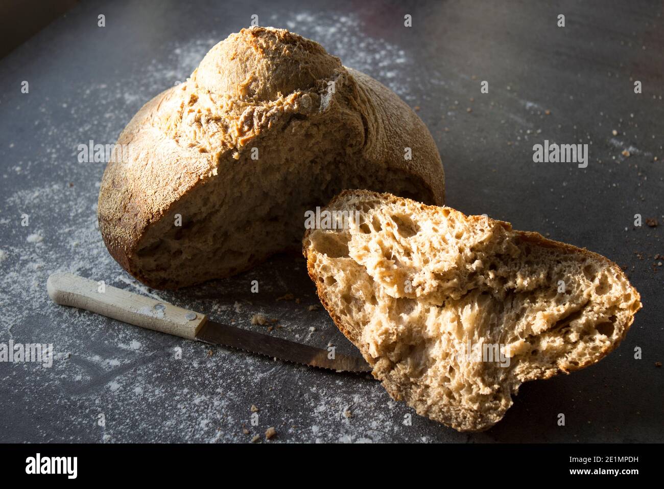 Primo piano di pane di pasta acida foto. Prodotti da forno freschi su un tavolo. Sfondo grigio con spazio per la copia. Delizioso pane integrale fatto in casa. Foto Stock