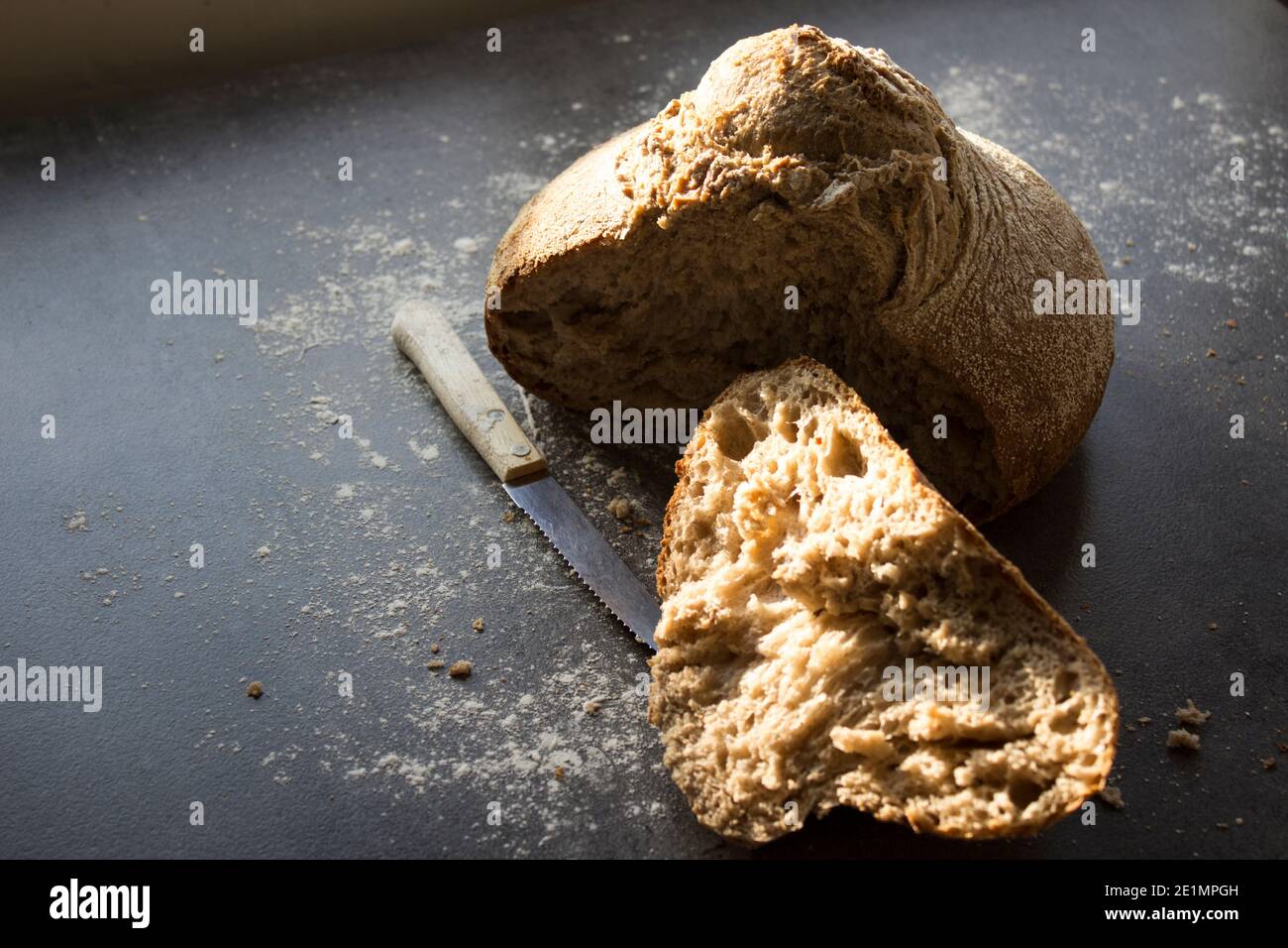 Primo piano di pane di pasta acida foto. Prodotti da forno freschi su un tavolo. Sfondo grigio con spazio per la copia. Delizioso pane integrale fatto in casa. Foto Stock
