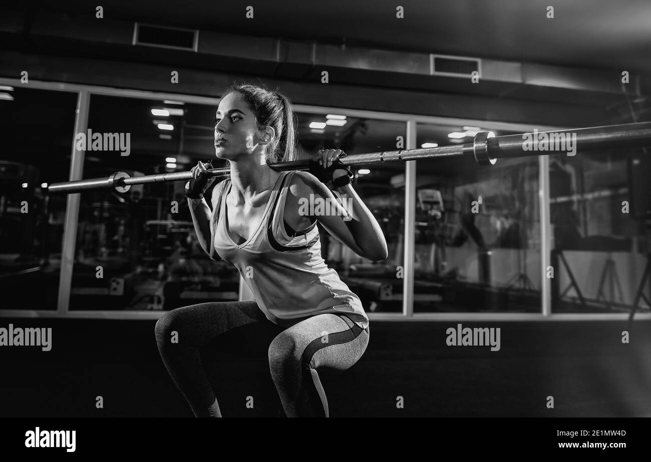 Primo piano di un giovane modello femminile di fitness forte facendo squadre con peso. Foto Stock