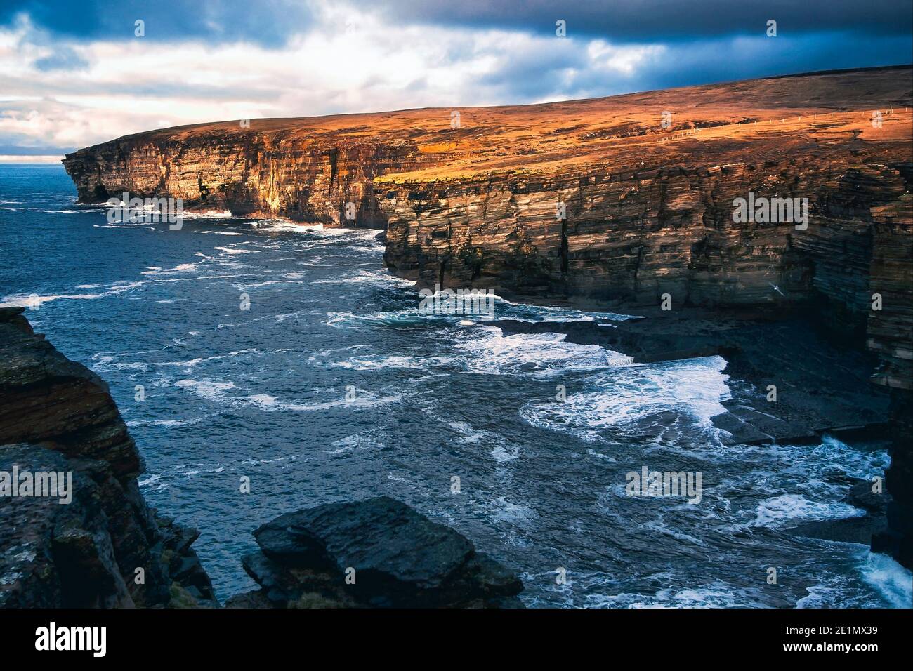 La luce del tramonto colpisce spettacolari scogliere sulla riva occidentale di Orkney isole nel nord della Scozia Foto Stock