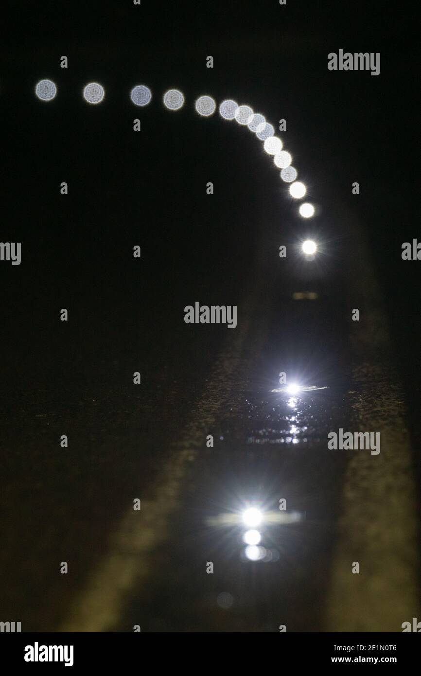 Gli occhi dei gatti o delle borchie da strada a LED alimentati a energia solare sono illuminati di notte sulla A675 Belmont Road, Lancashire, Inghilterra, Regno Unito Foto Stock