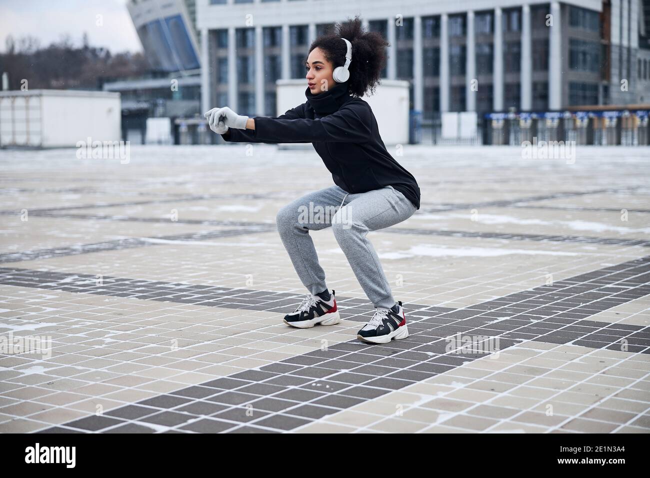 Atleta concentrato facendo squadre su una piazza Foto Stock