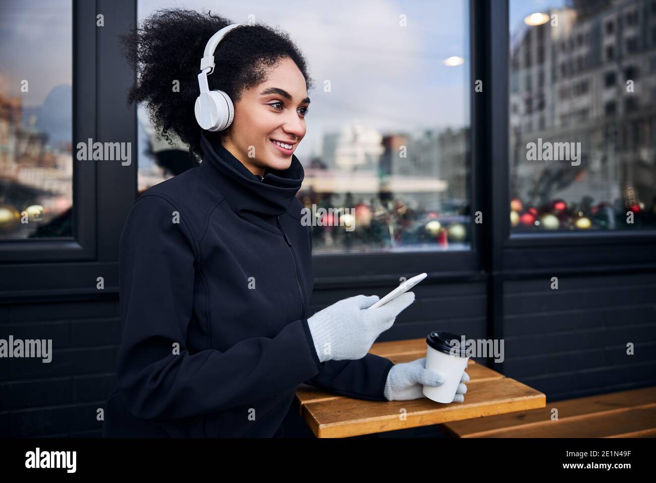 Ospite femminile che guarda alla strada con uno smartphone Foto Stock