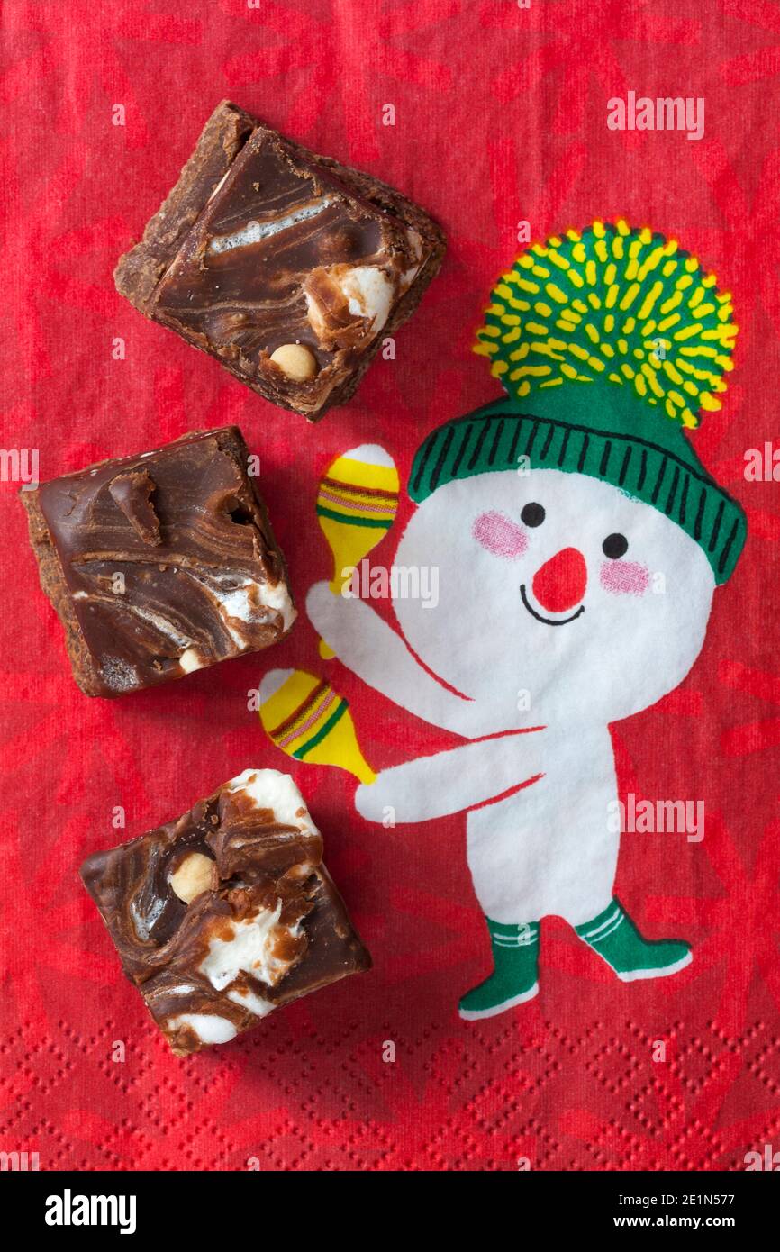 M&S Smores Fudge Squares su tovagliolo di serviette natalizie - scuro fondente di cioccolato con pezzi di biscotto e marshmallows aromatizzati alla vaniglia Foto Stock