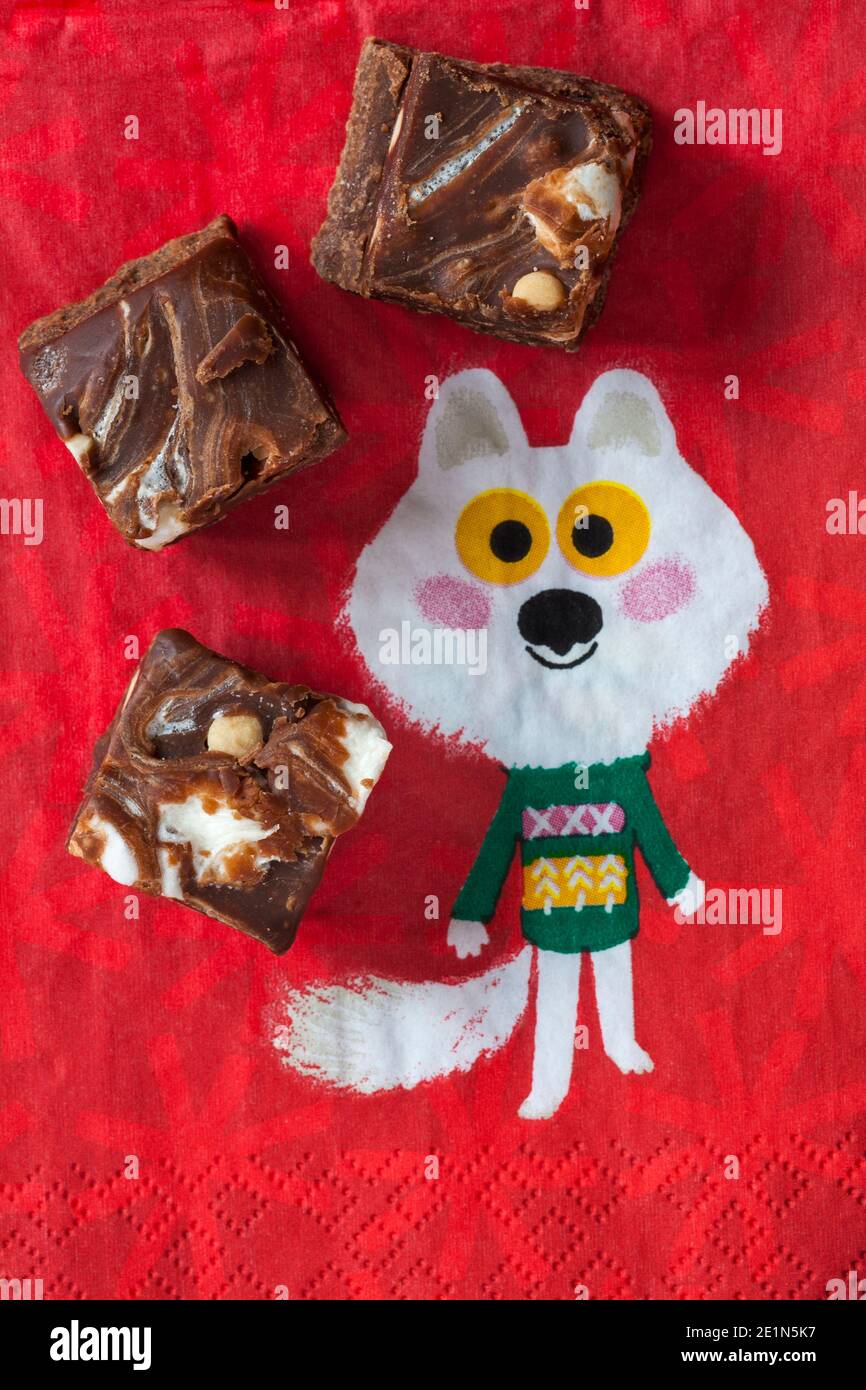 M&S Smores Fudge Squares su tovagliolo di serviette natalizie - scuro fondente di cioccolato con pezzi di biscotto e marshmallows aromatizzati alla vaniglia Foto Stock