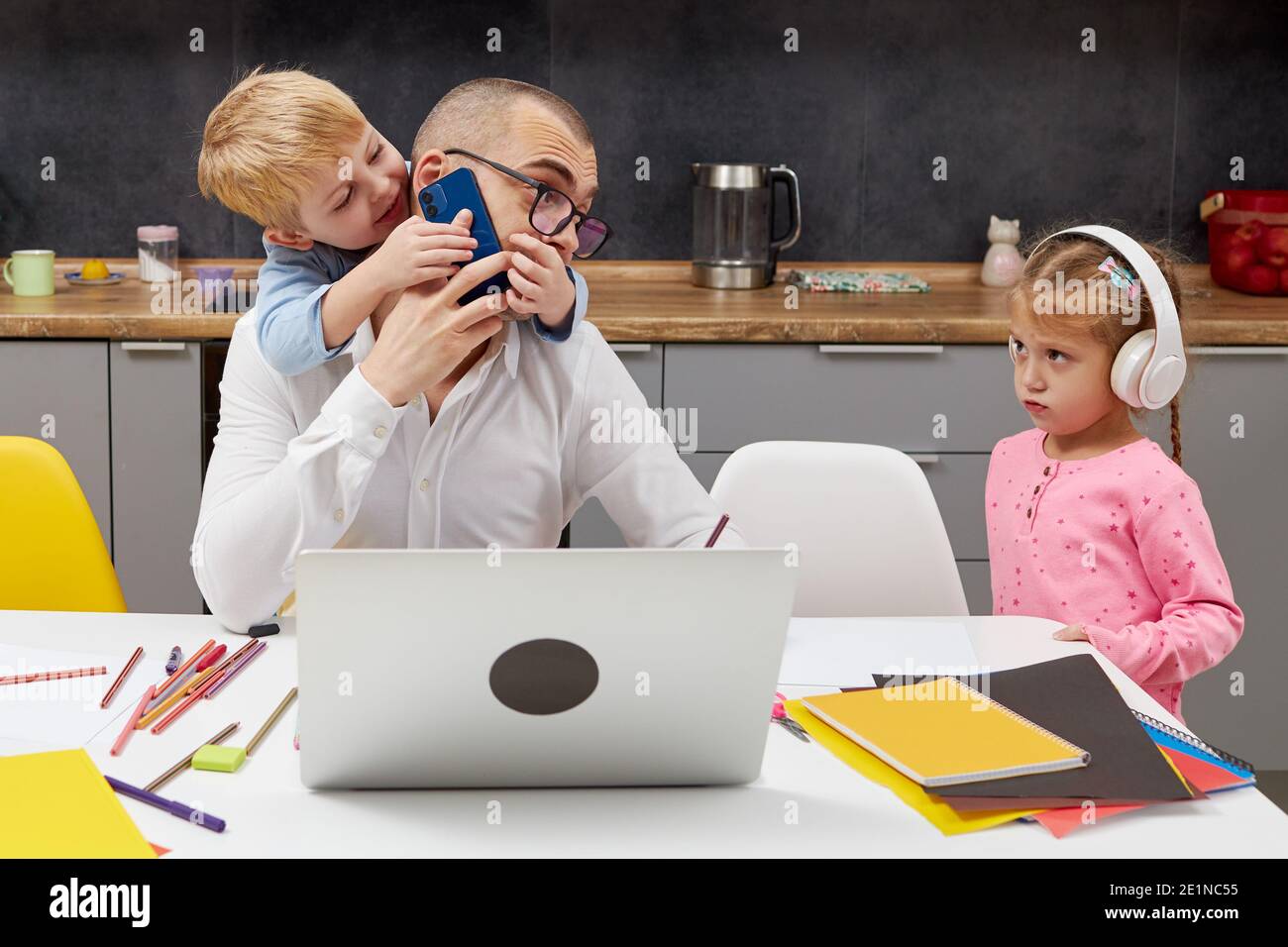 Padre che lavora da casa durante la quarantena e chiuso la scuola. Epidemia di coronavirus. Giovane uomo d'affari freelance lavora su laptop con childre Foto Stock