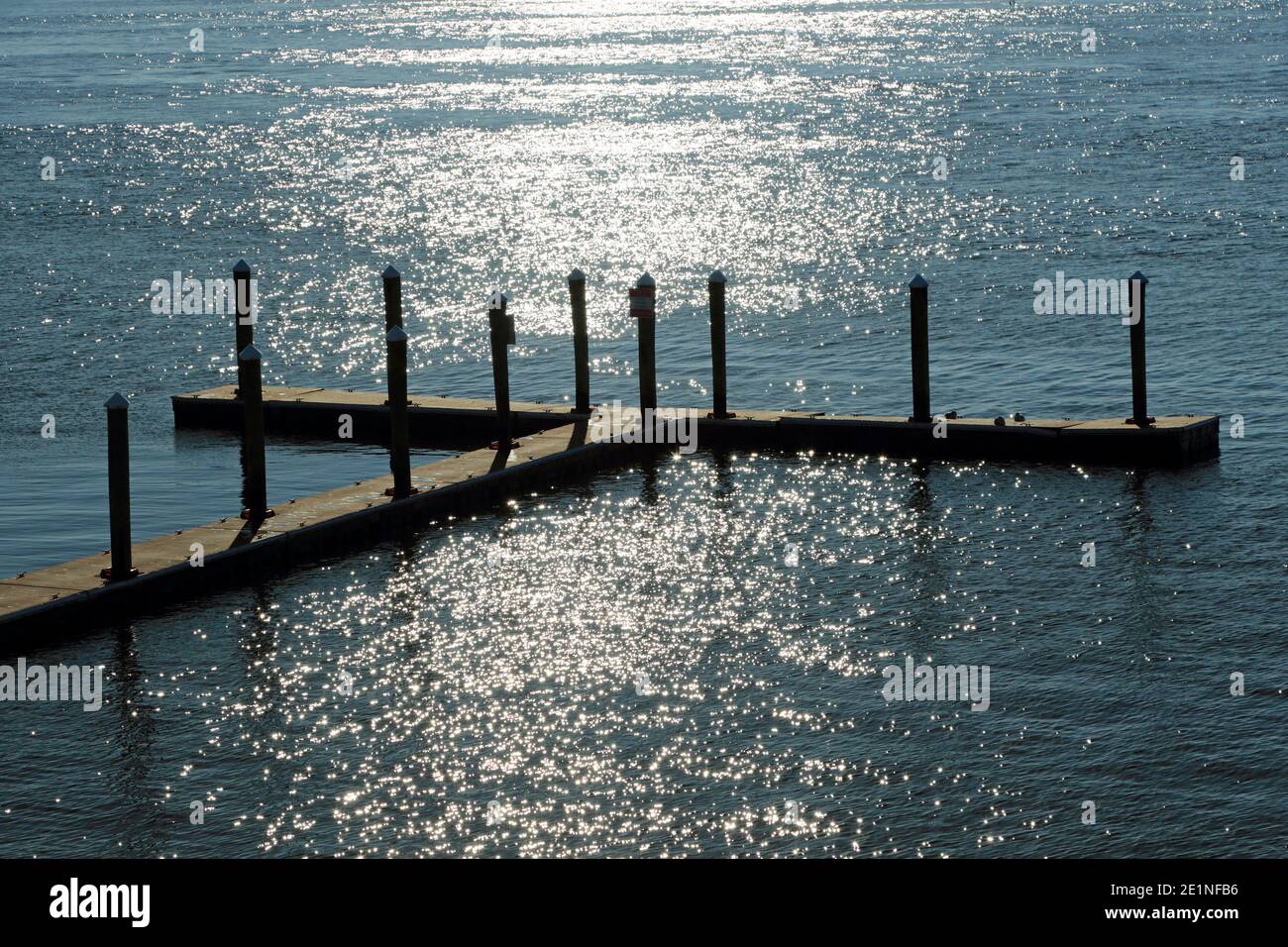 Un molo vuoto trascende in una croce di ispirazione nel bagliore del sole. Sommers Point, New Jersey, Stati Uniti Foto Stock