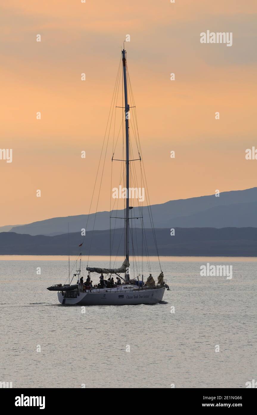 Lo yacht Alba Endeavour si fa strada da Oban dopo il tramonto in Scozia, Regno Unito Foto Stock