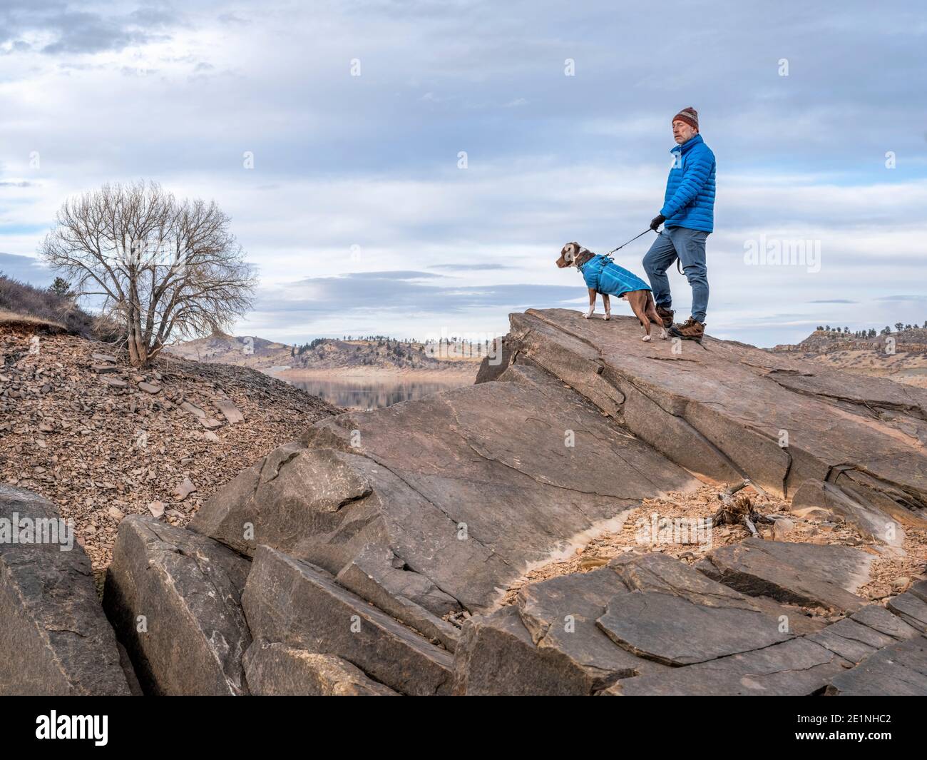 L'escursionista maschile senior sta camminando con il cane pitbull su una riva di lago di montagna ai piedi delle Montagne Rocciose, Horsetooth Reservoir - una famosa ricreazione Foto Stock