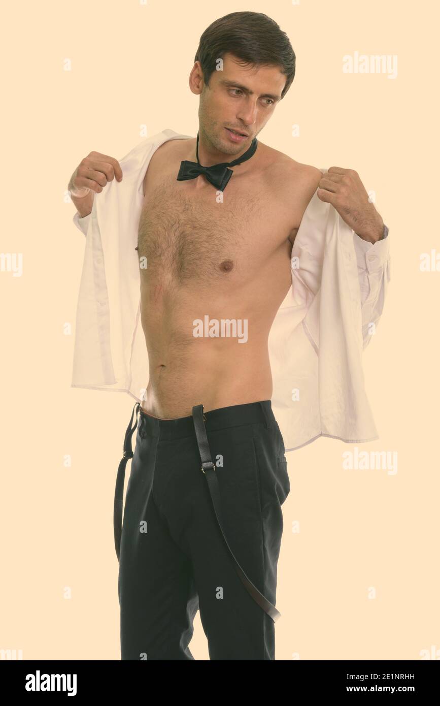Studio shot del giovane uomo bello maglietta di apertura e di pensare mentre si indossa il filtro bow tie Foto Stock