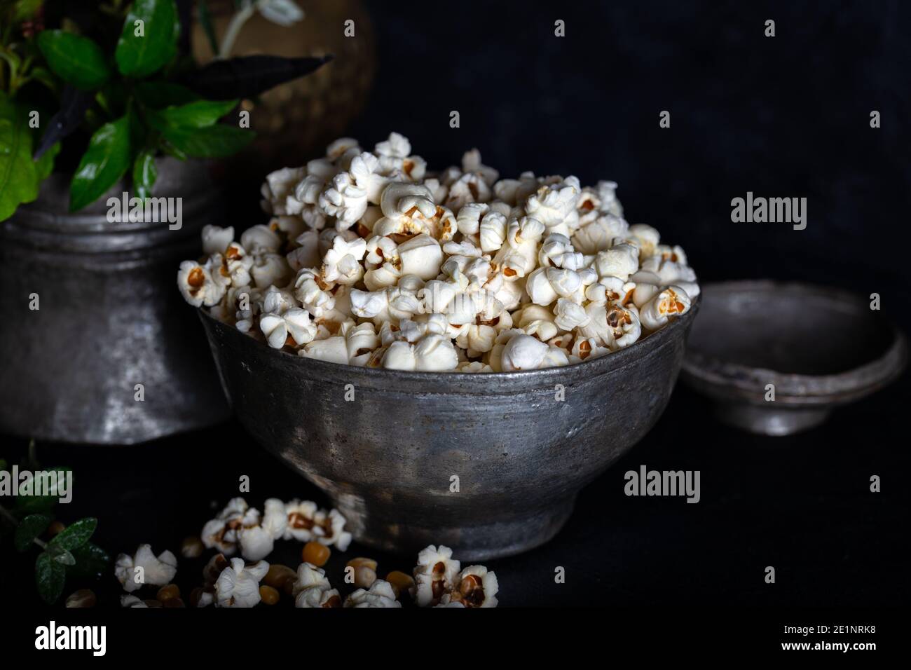 Popcorn preparato in padella, semi di mais in ciotola e mais su fondo scuro. Foto Stock