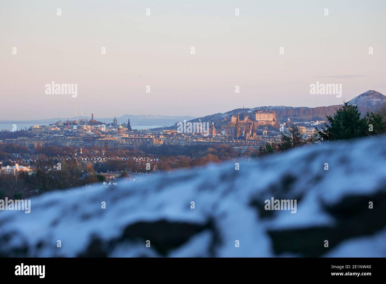 Una vista invernale con neve, guardando da Corstorphine Hill verso il centro di Edinbugh (Scozia). Il castello e Arthurs sede in background. Foto Stock