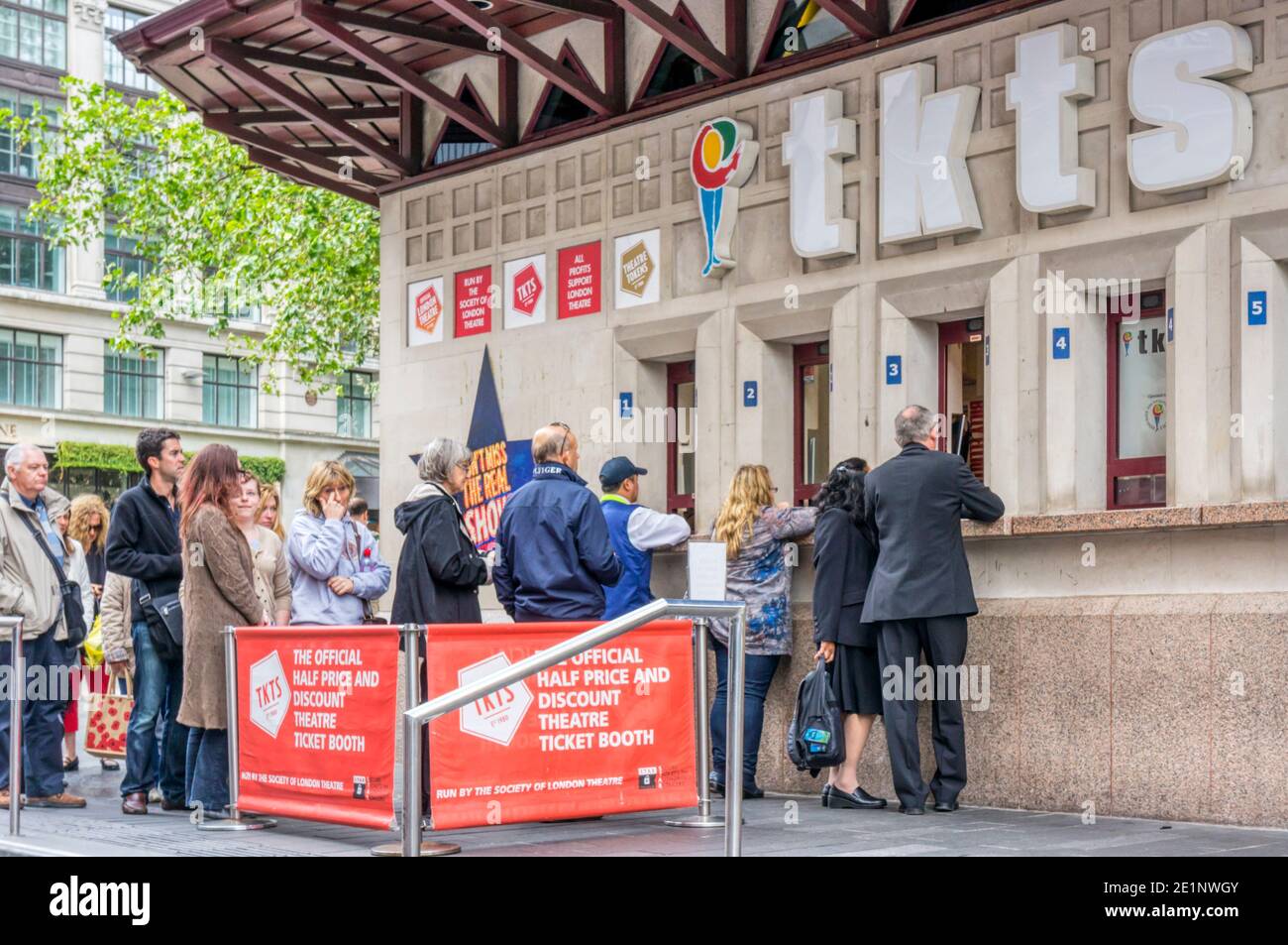 Le persone che si accodano alla biglietteria TKTS di Leicester Square, vendono biglietti giornalieri a metà prezzo per i teatri di Londra. Foto Stock