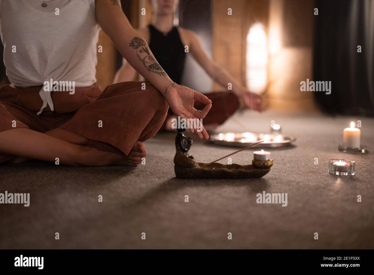 Anonimo donna gesturing Gyan mudra e meditando in Lotus posa vicino all'incenso Foto Stock
