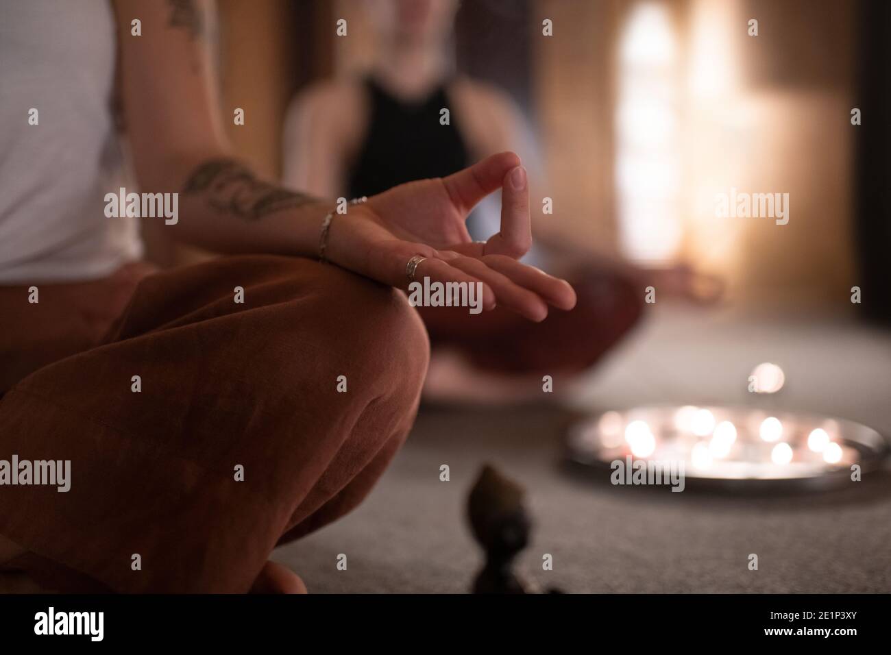 Donna anonima gesturing Gyan mudra e meditating durante la sessione in camera oscura Foto Stock