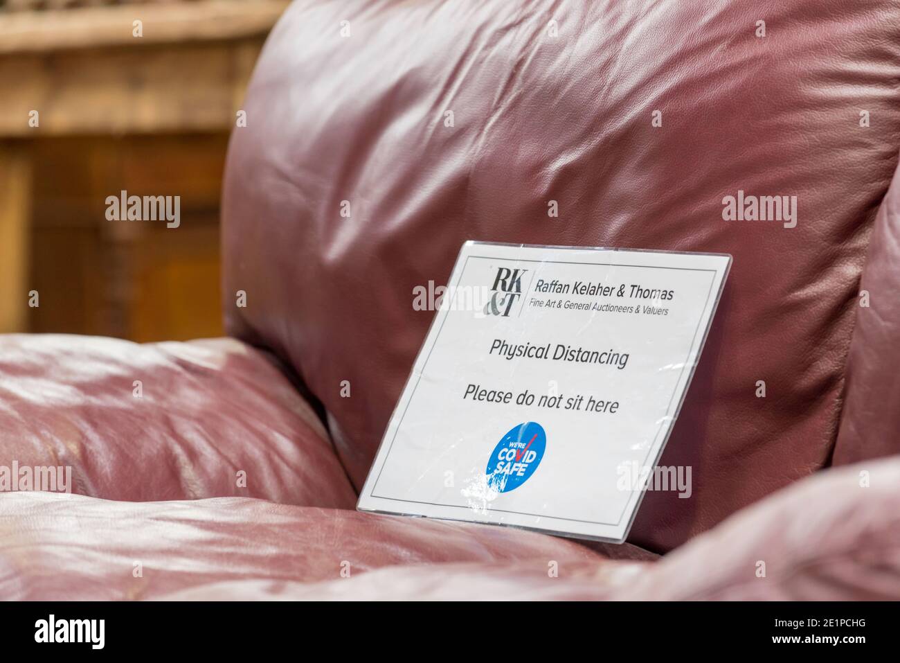 Una poltrona in pelle a Sydney, Australia con un Covid-19 non sedersi qui segno per aiutare con la distanza fisica Foto Stock