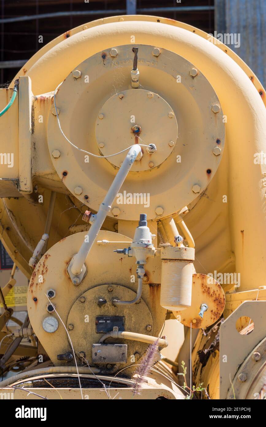 Un'immagine verticale anonima, in primo piano di arrugginimento disusato verniciato giallo, macchinari pesanti Foto Stock