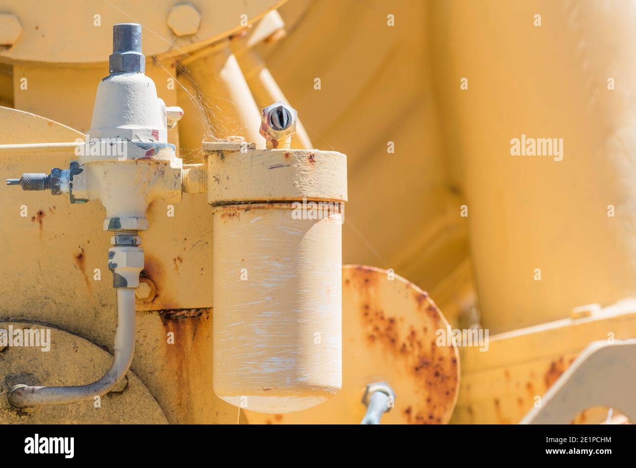 Un'immagine in primo piano anonima orizzontale di arrugginimento disusato giallo verniciato, macchinari pesanti Foto Stock