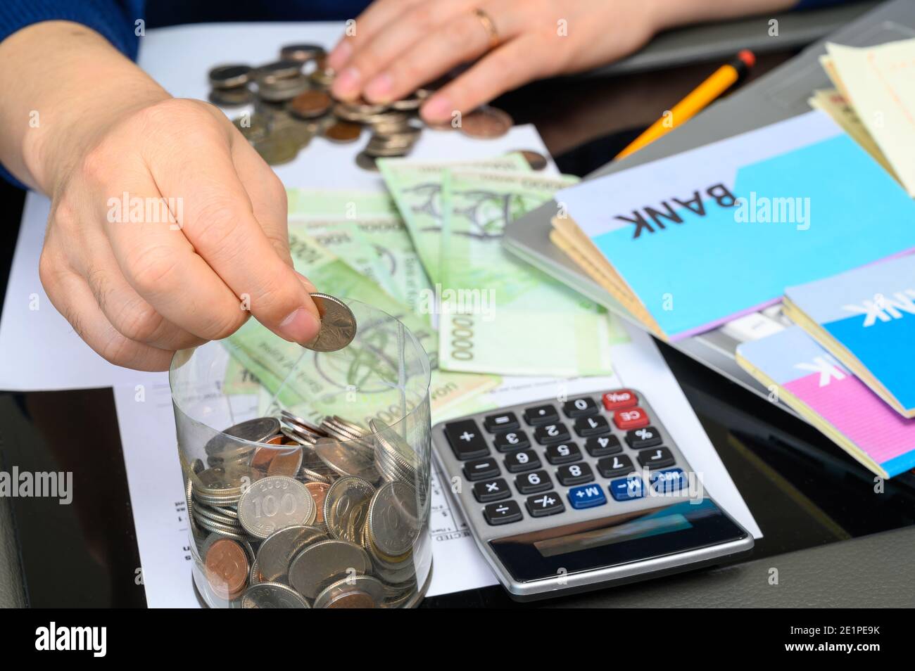 Le mani degli uomini che tengono un libretto bancario e tessono un bilancio. Foto Stock