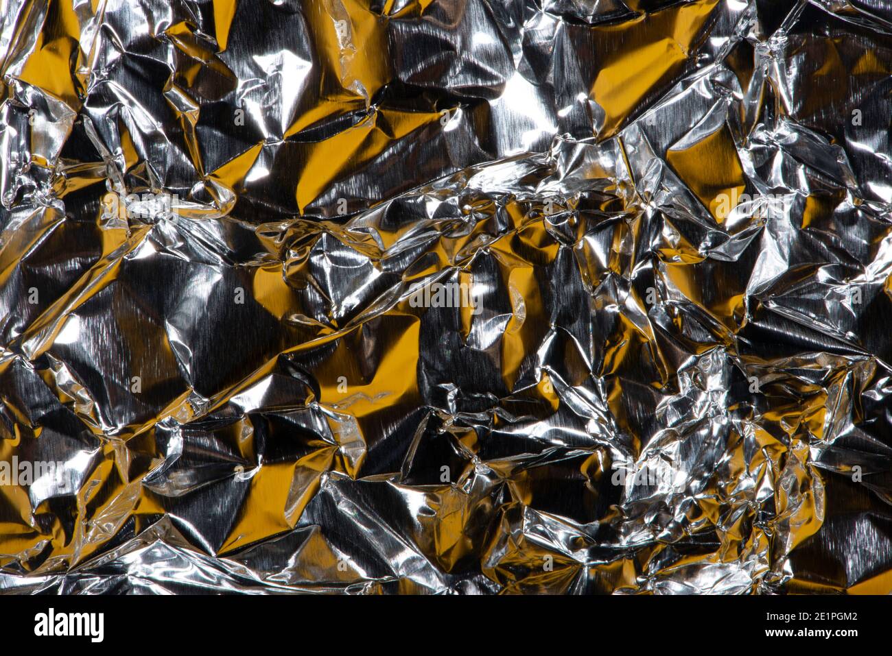 Sfondo astratto con struttura in lamina sminuzzata, colori argento e giallo. Foto Stock